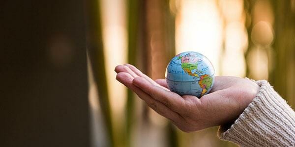 a hand holding a small globe